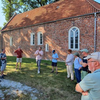 Die Tourteilnehmer*innen versammeln sich vor der Johanniterkapelle Bokelesch.