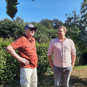 Joachim Bunger und Stephan Christ unterhalten sich im Garten bei der Johanniterkapelle Bokelesch.