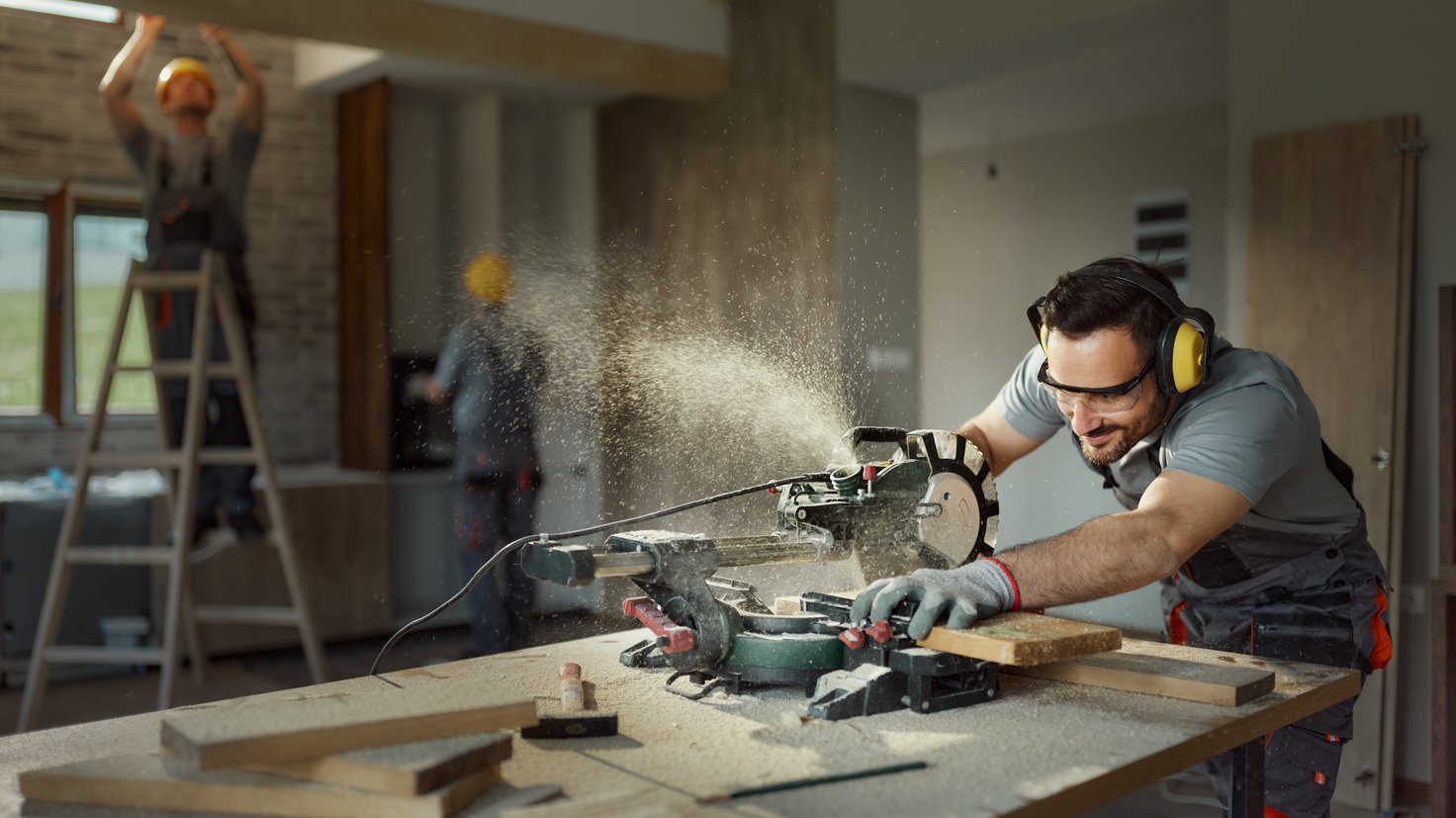 Sinnbild für Wirtschaft & Soziales: Tischler und Innenausbauer arbeiten gemeinsam in einem Raum.